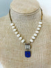 Vintage Charite medal hangs from a vintage rhinestone element, freshwater pearls and vintage chain