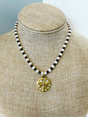 Swarovski crystal gold bee pendant hangs from a necklace of alternating garnets and freshwater pearls 