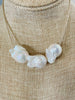 three white baroque pearls on a necklace of antique gold lined beads 
