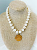 white freshwater pearls and brass colored french coin pendant 