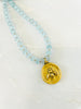gold french bee charm necklace and blue beads